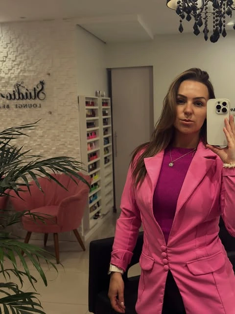 Cláudia Aires, Kakau, usando blazer rosa no espaço de atendimento